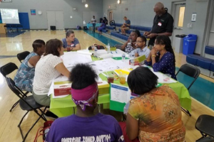 participants sitting in chairs with papers on a table at a recreation center