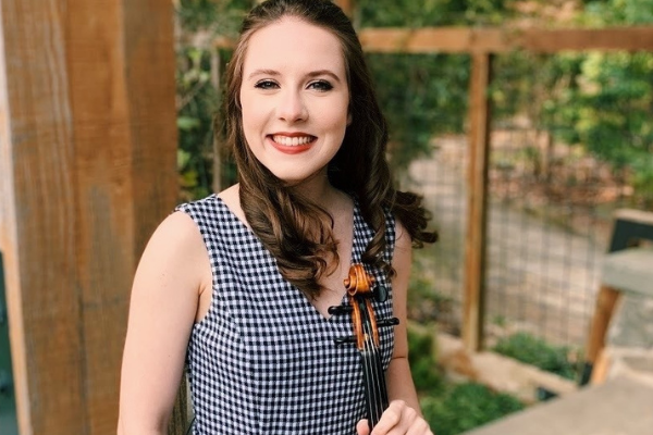 photo of recent graduate holding a violin 
