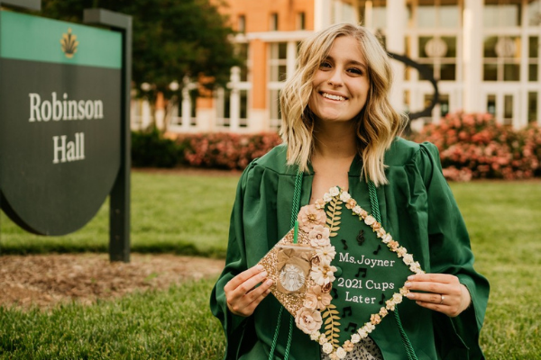 photo of recent graduate holding her cap with flowers on it