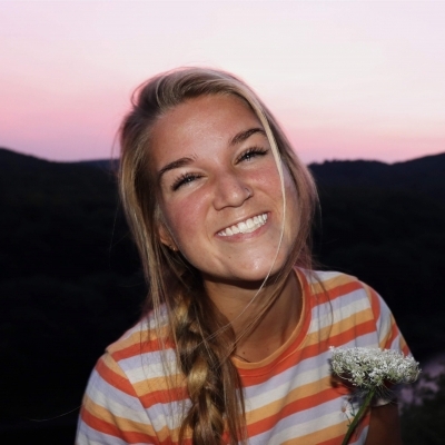 Meredith Pack smiling in front of purple sky in the mountains 