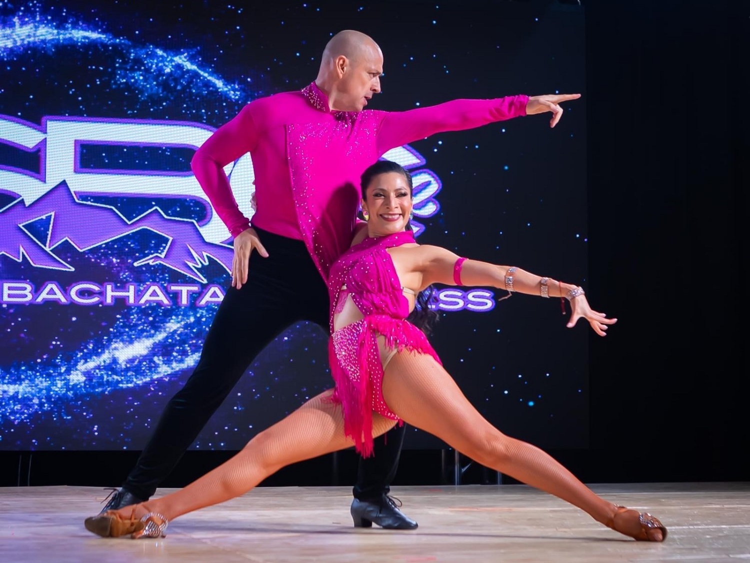 Rodrigo and Wendy in pink costumes at a dance competition