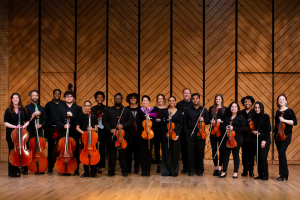 the Charlotte Strings collective standing with instruments smiling at camera