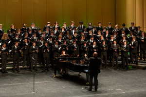 male students onstage singing