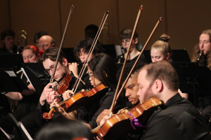 students playing string instruments on stage