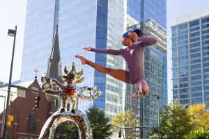 Alabi Orisadele leaping over the Firebird sculpture uptown.