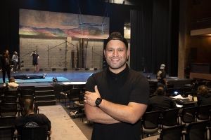Carlos Cruz in a theatre with the stage behind him