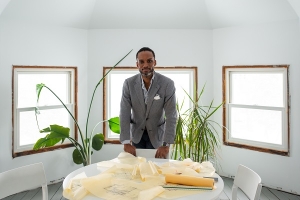 Sekou Cooke at a table with architecture plans