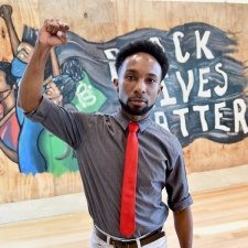 Jamil Dyair Steele in front of his Black Lives Matter mural