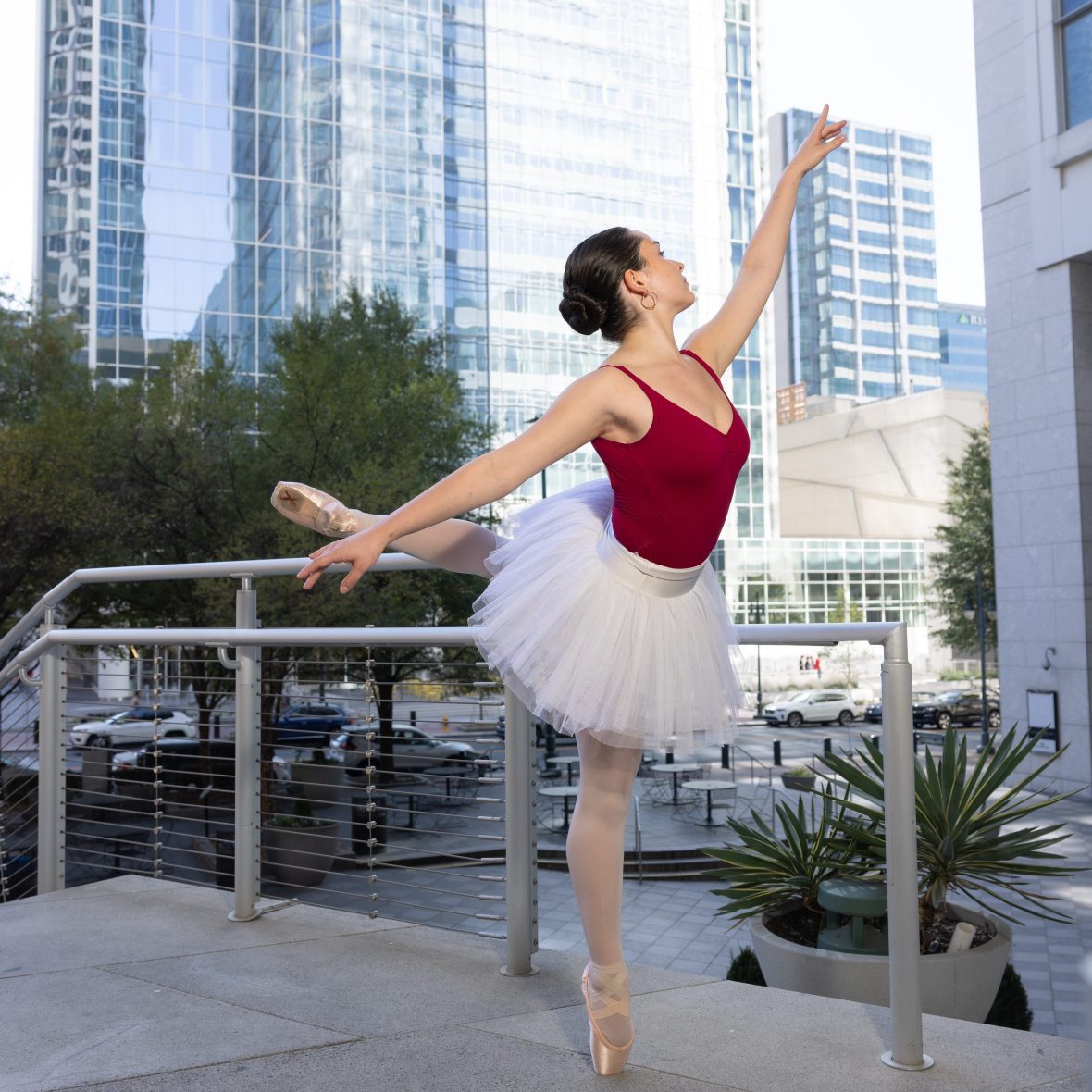 Dancer in uptown with Charlotte skyline in the background in arabesque