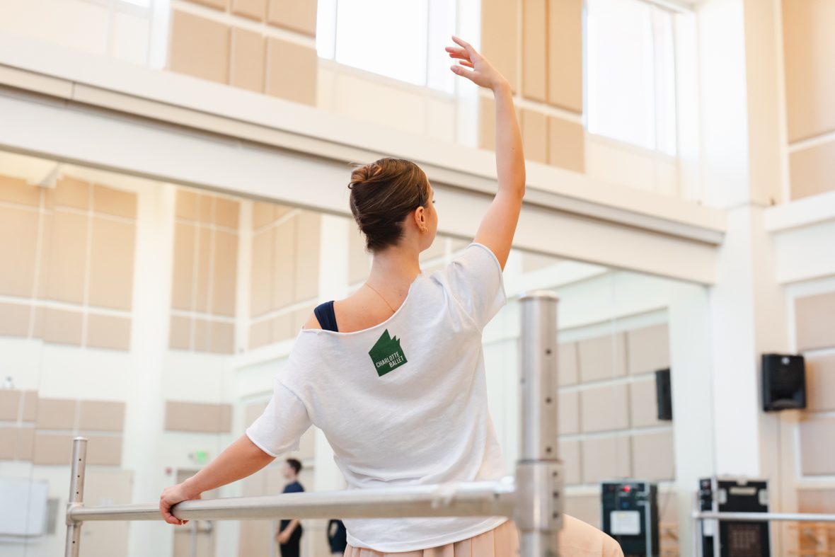 Kari at the ballet barre facing backward so you can see her Charlotte Ballet logo on her tshirt