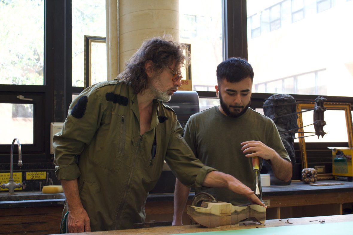 professor and student working together on a sculpture in the studio