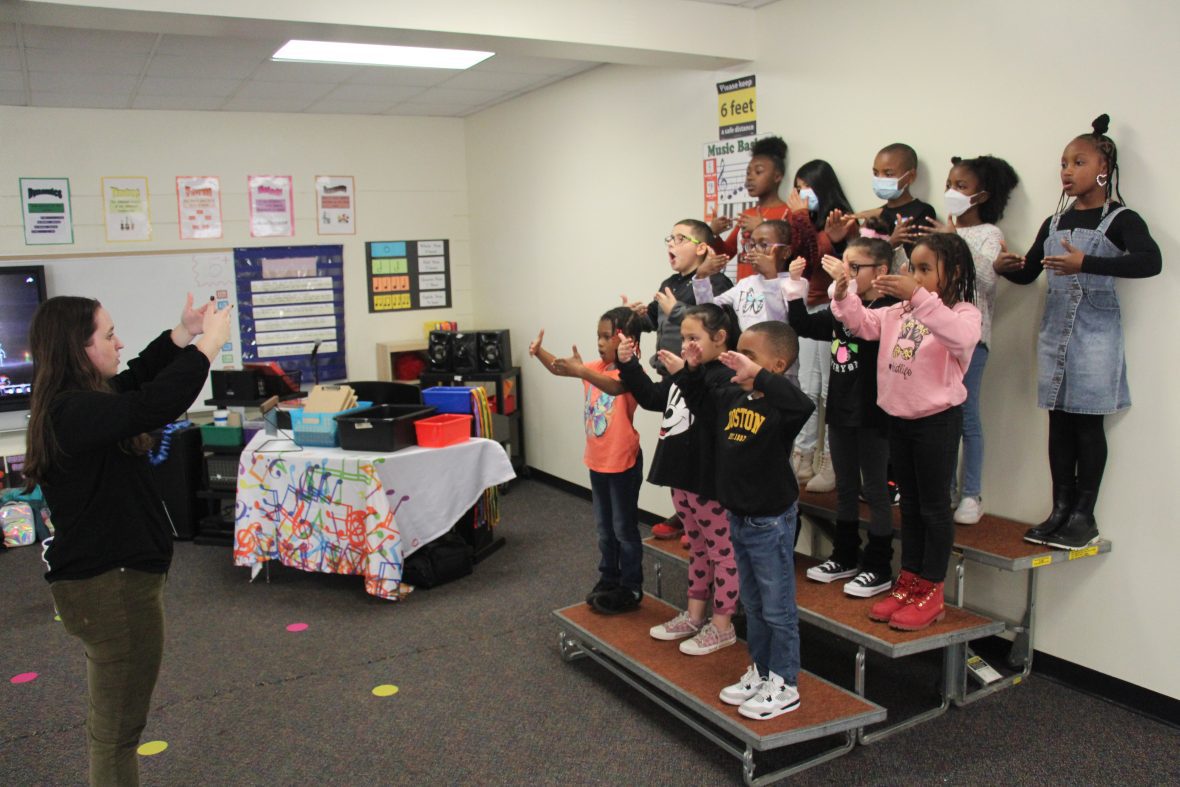 Music teacher conducting her young class in chorale activities