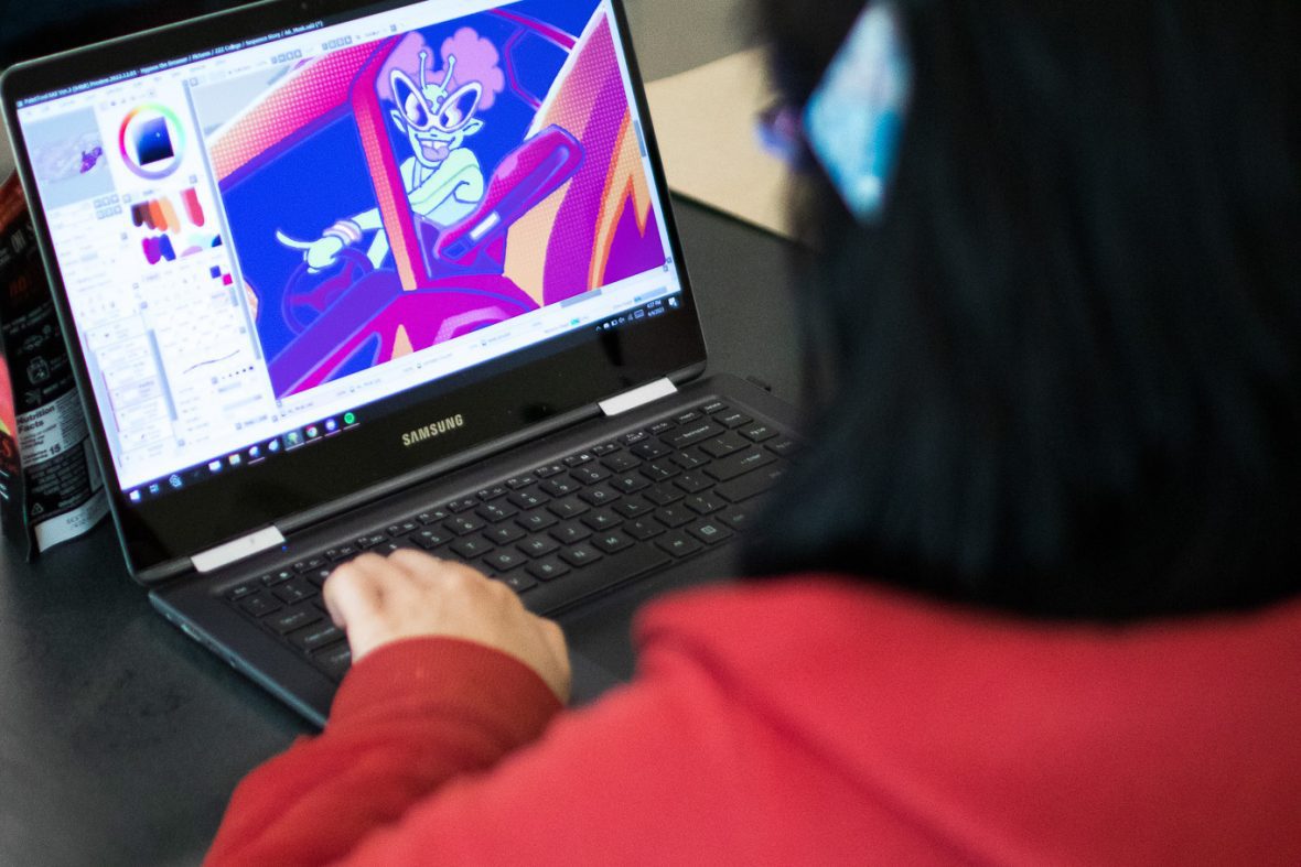 view of student from behind head looking at her computer screen and working on a digital illustration