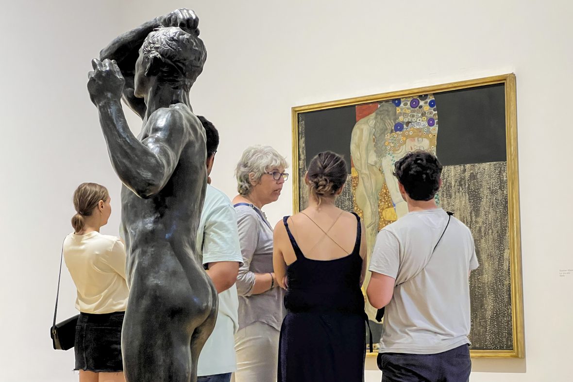 student in a gallery in Rome, sculpture in the foreground