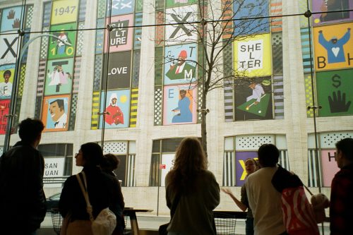 students looking at art on a building 
