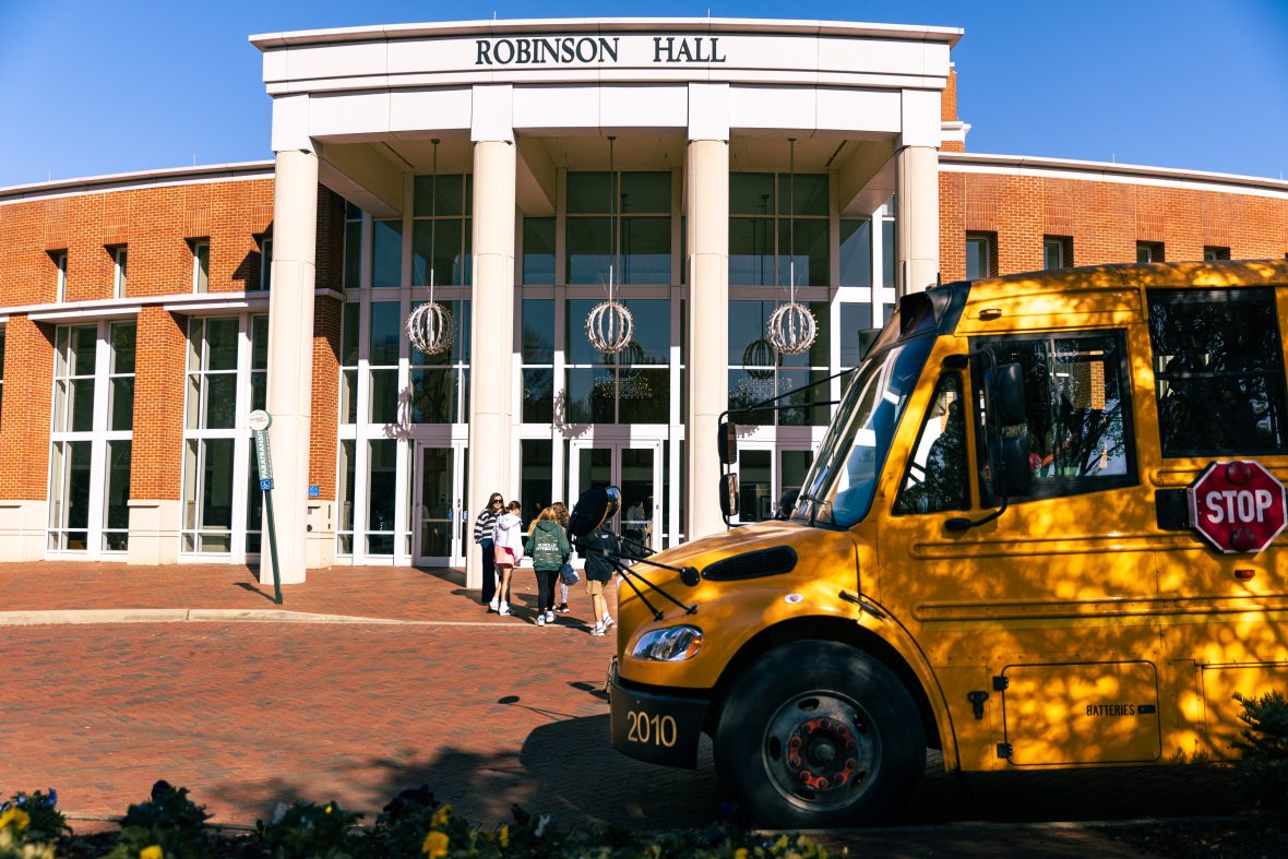 Students coming out of school bus and going into the front door of Robinson Hall.