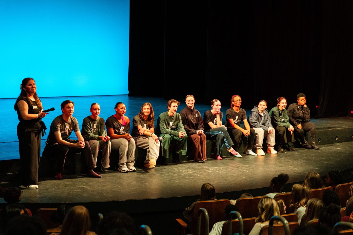 students sitting on edge of stage for Q & A