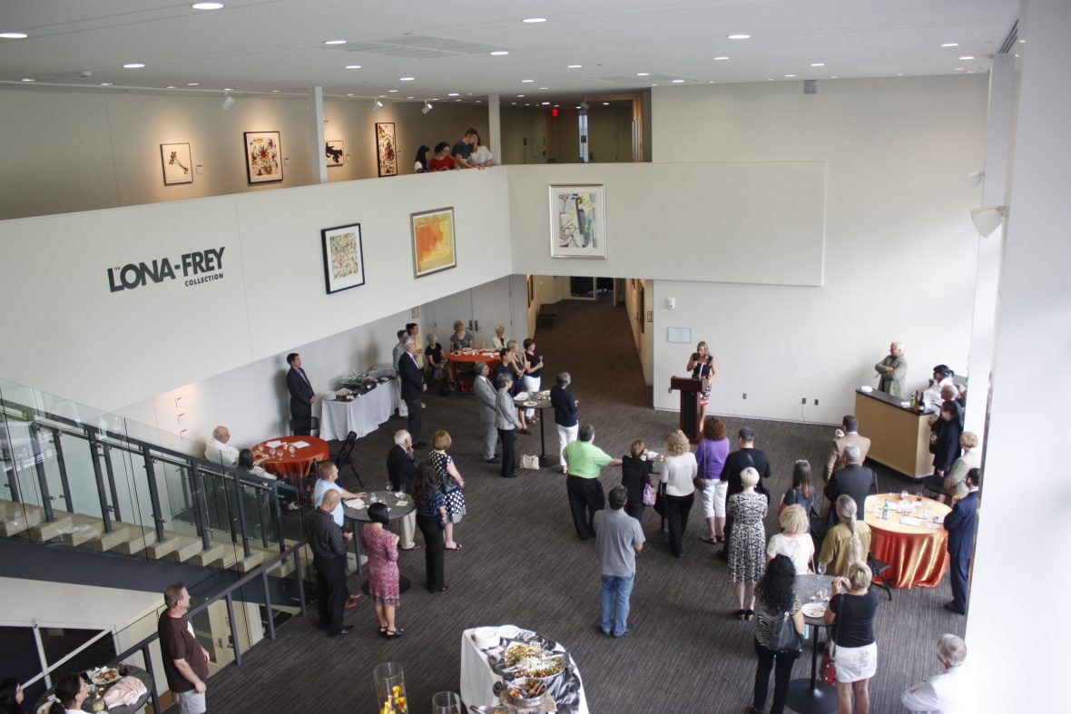 people gathered in a lobby with art on the wall