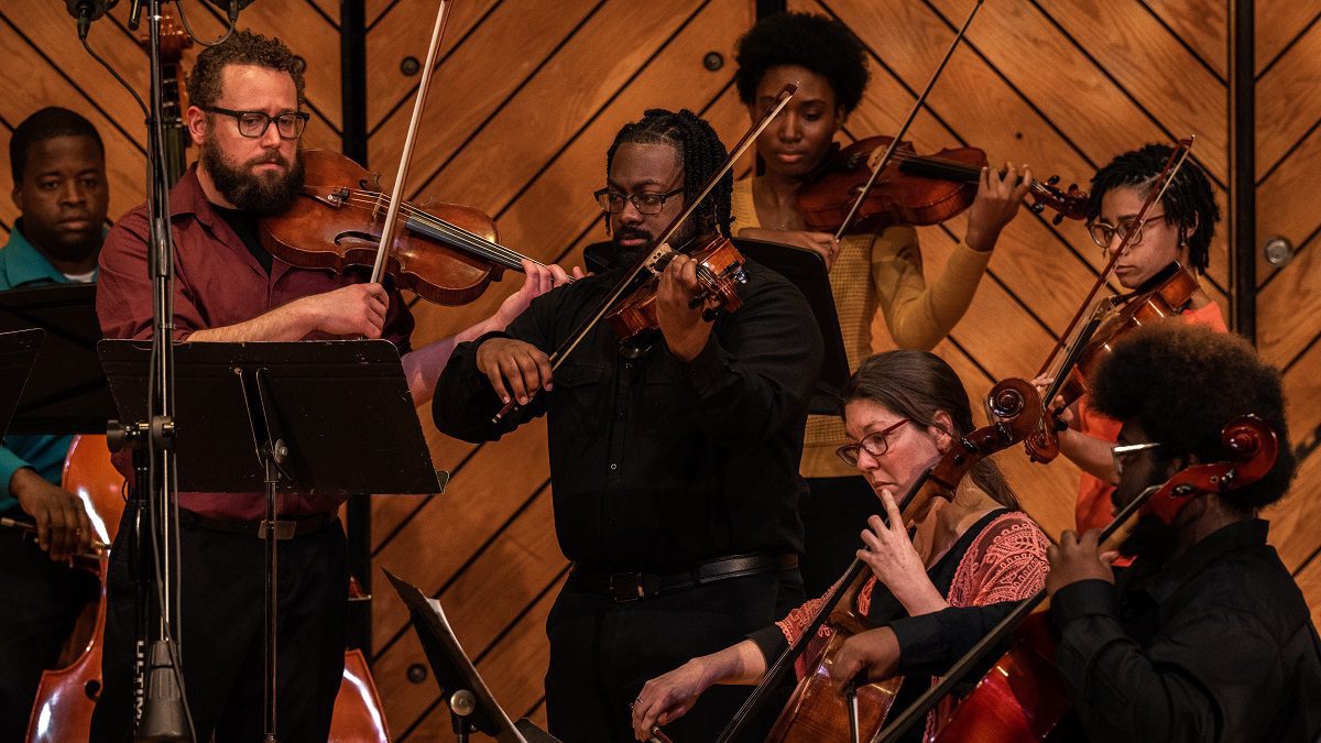 students playing in the orchestra on stage
