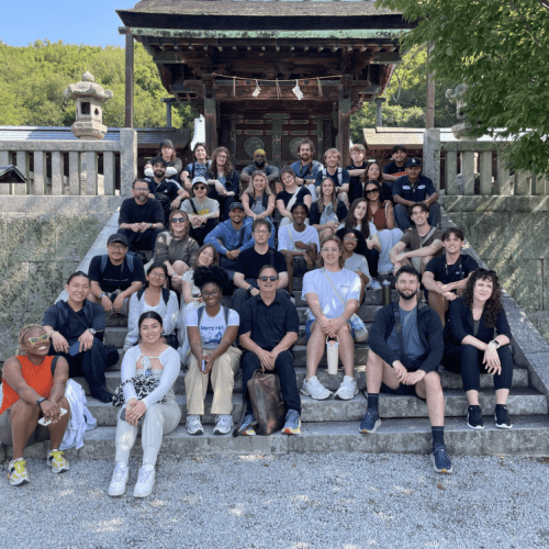 students sitting outside of a temple on the stairs 