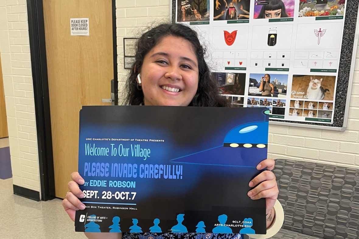 Student holding up a blue poster that she designed