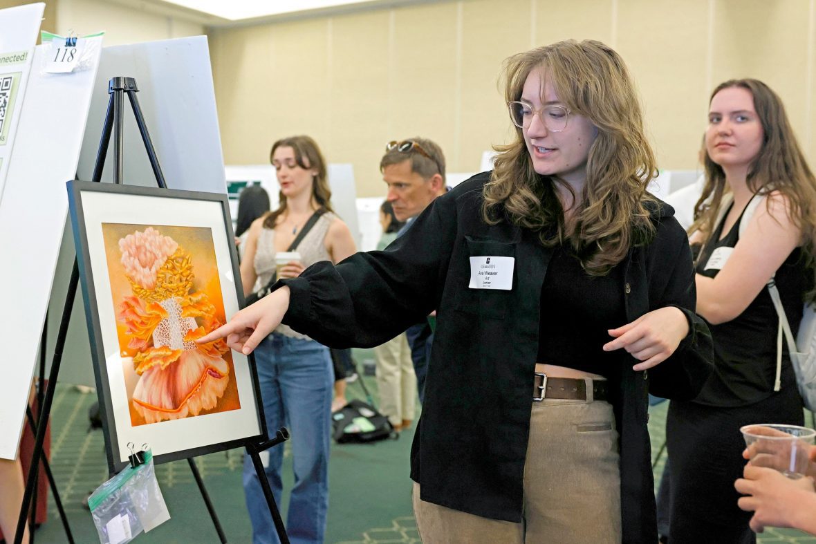 Student presenting her artwork at an undergraduate research symposium