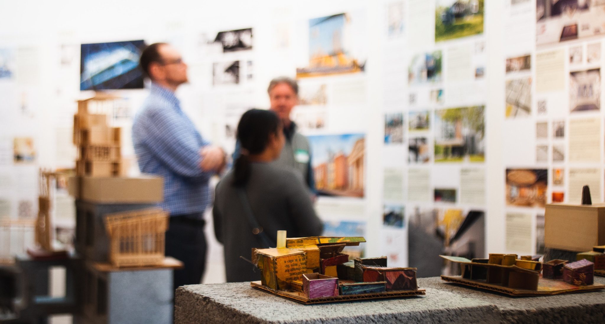 close up of a gallery model and people looking on the walls