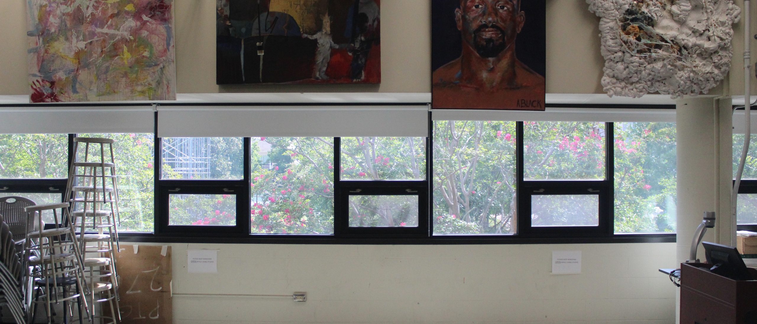 View of windows in the painting studio with paintings above