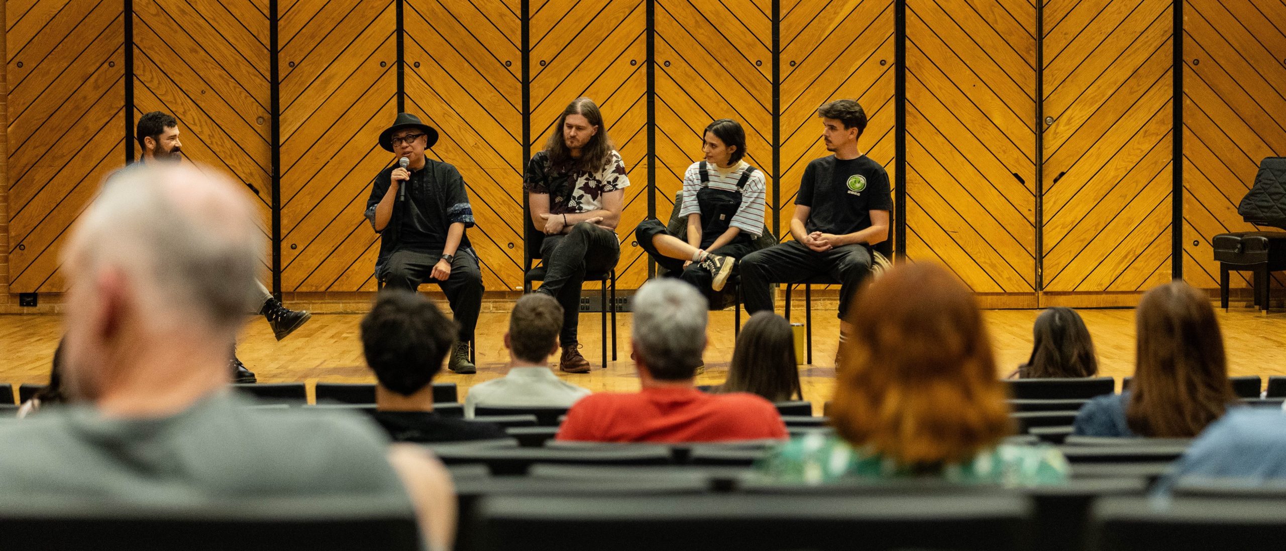 Four artists sitting on stage four panel
