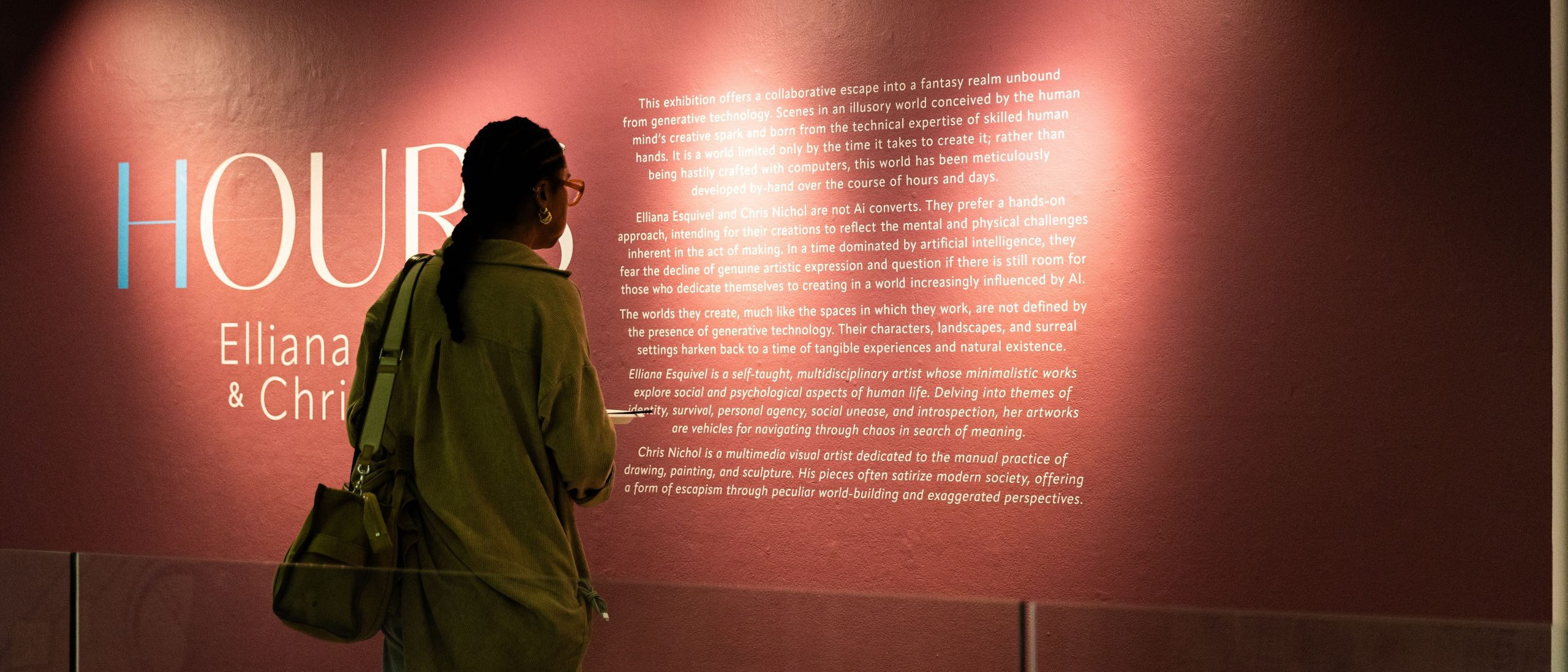 Student reading the description of a gallery on the wall