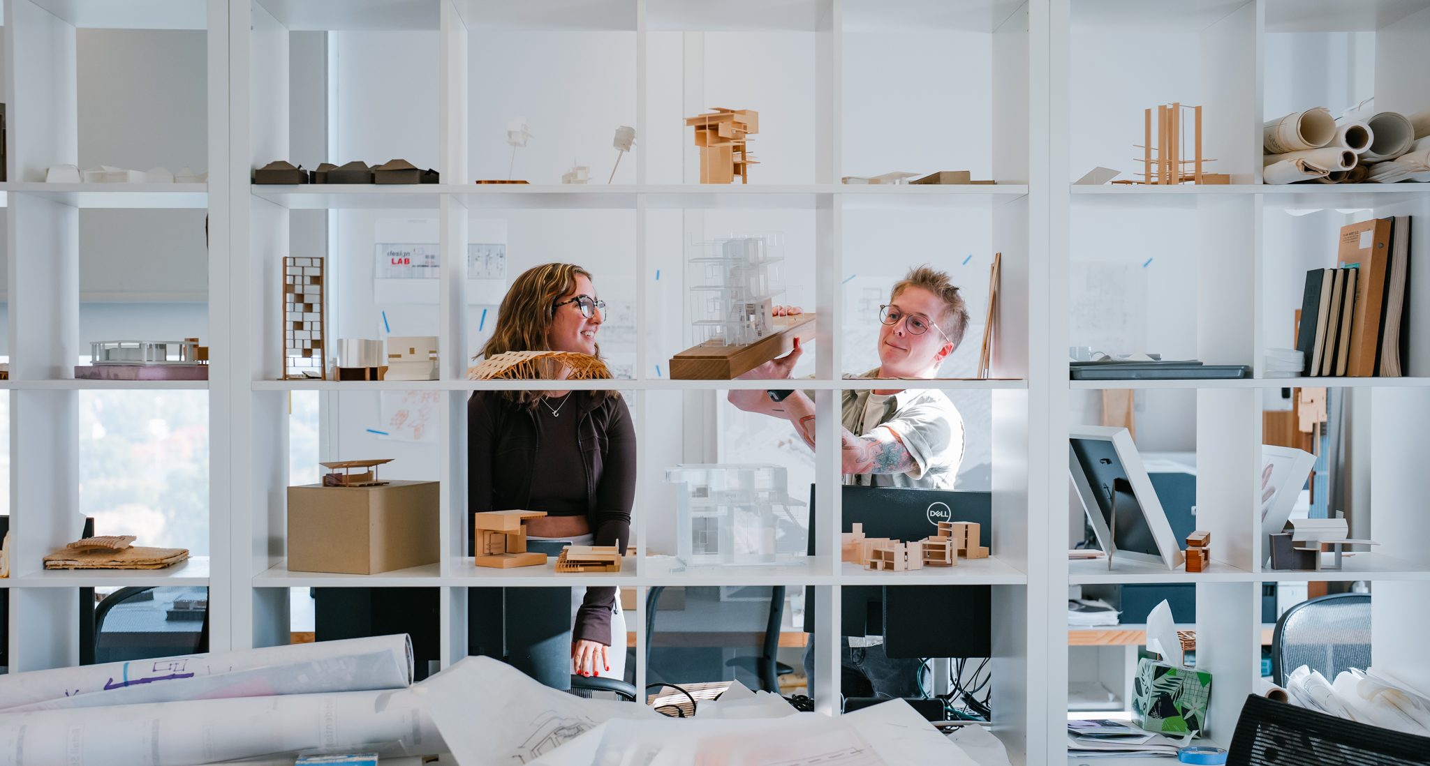 two students putting a model on an open cubby