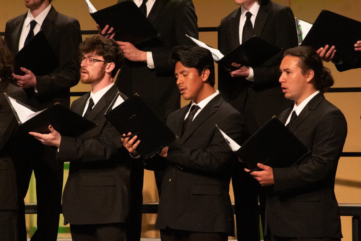 Mens chorus singing in black suites