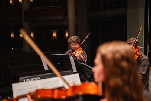 A male orchestra student on stage focus on him