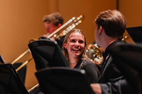 Student looking next to her and smiling on stage