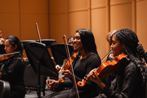 Two orchestra female students playing the violin