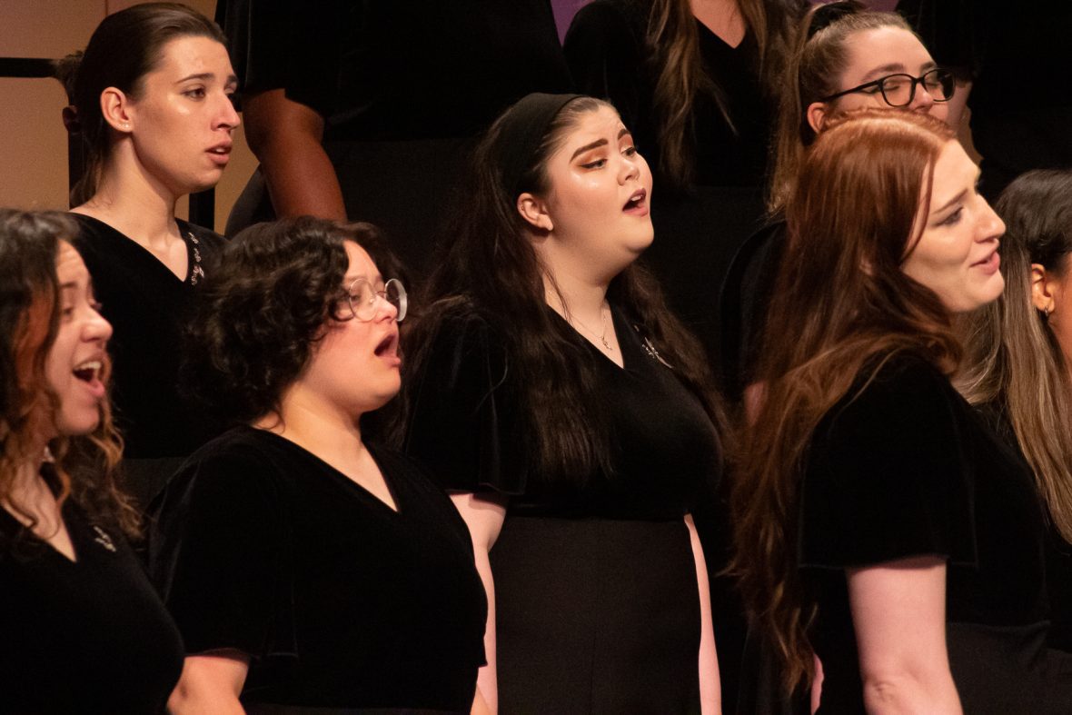 Womans chorus singing in black dresses