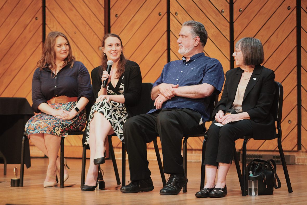 four alumni sitting on stage talking