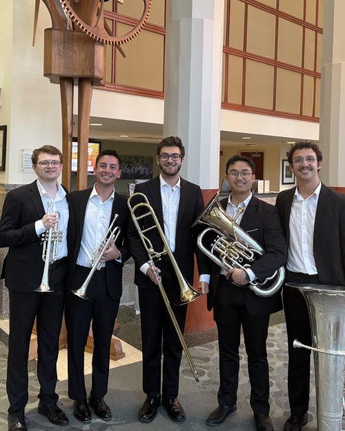 group of men dressed in suits holding their instruments in the lobby