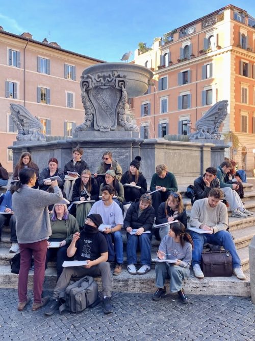 architecture class sitting at a fountain with their sketchbooks 
