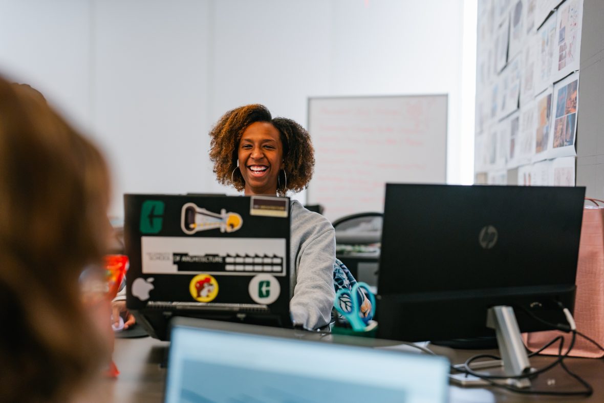 student smiling behind her computer