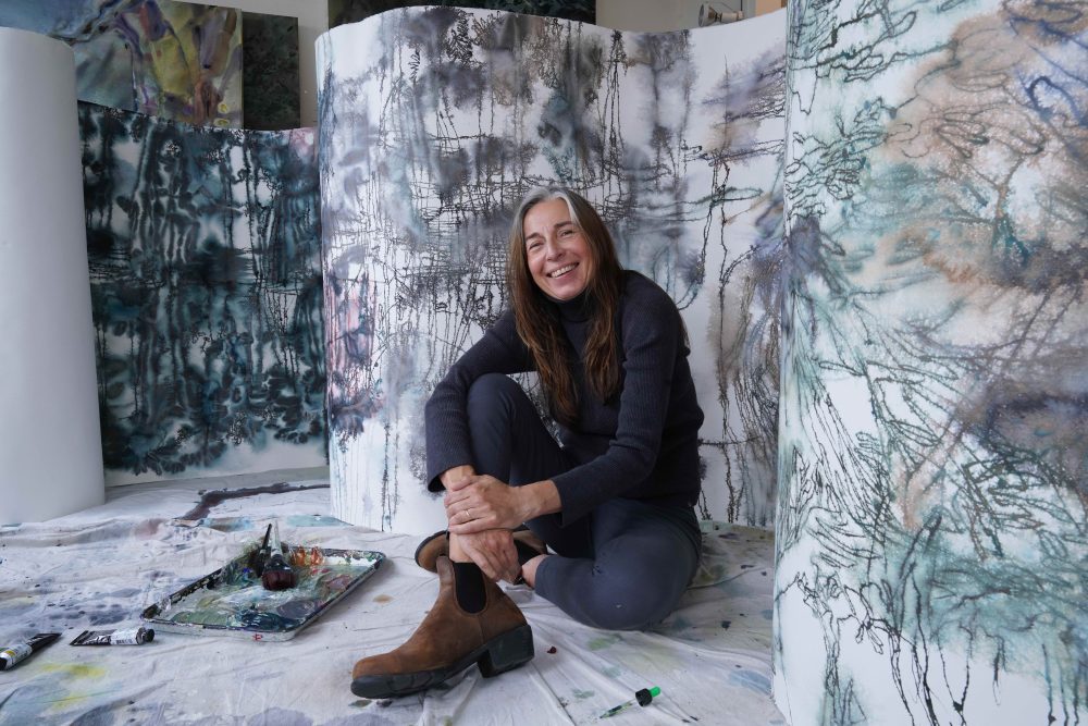 Maja in front of her art sitting on the floor