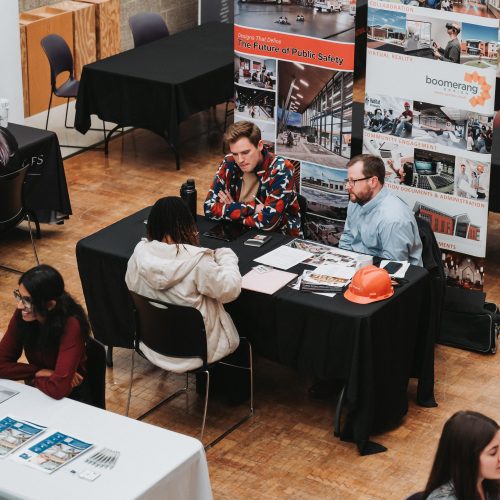 two professionals talking to a student