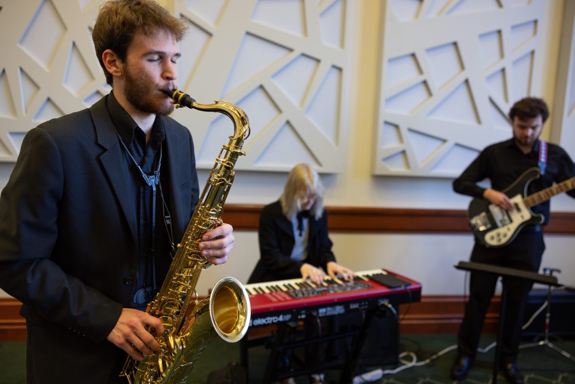Jazz students playing; one on saxophone, keyboard, and bass