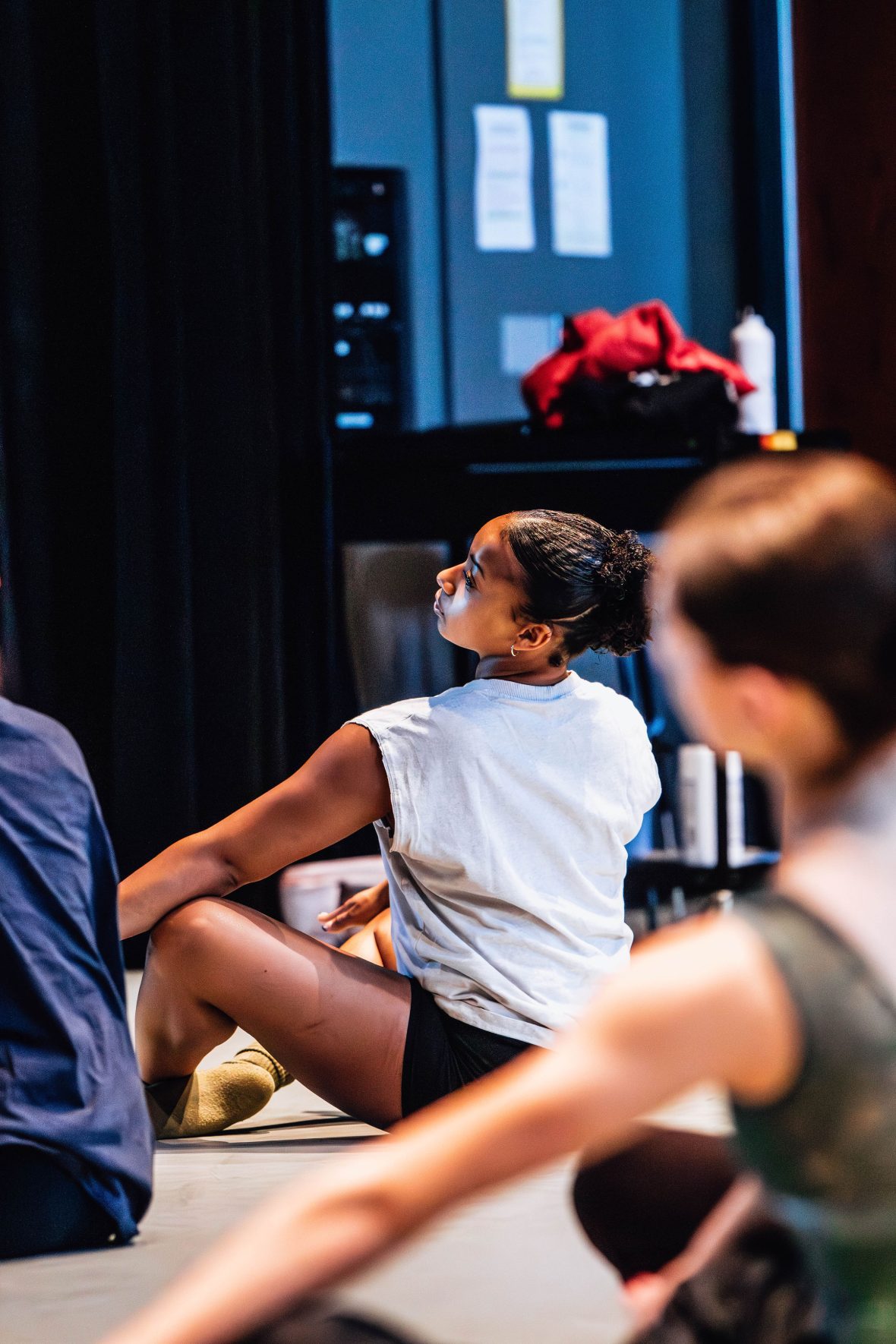 Student on the floor in the studio in a Graham warmup position