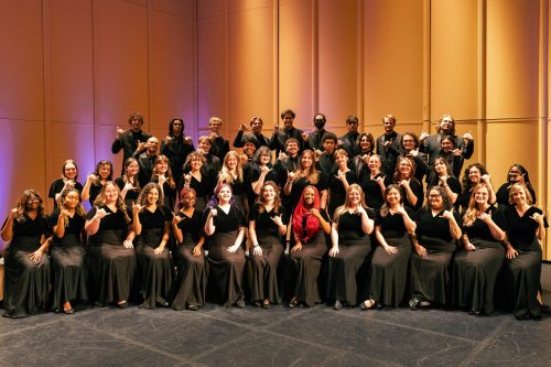 Choir on stage making pick-axe sign