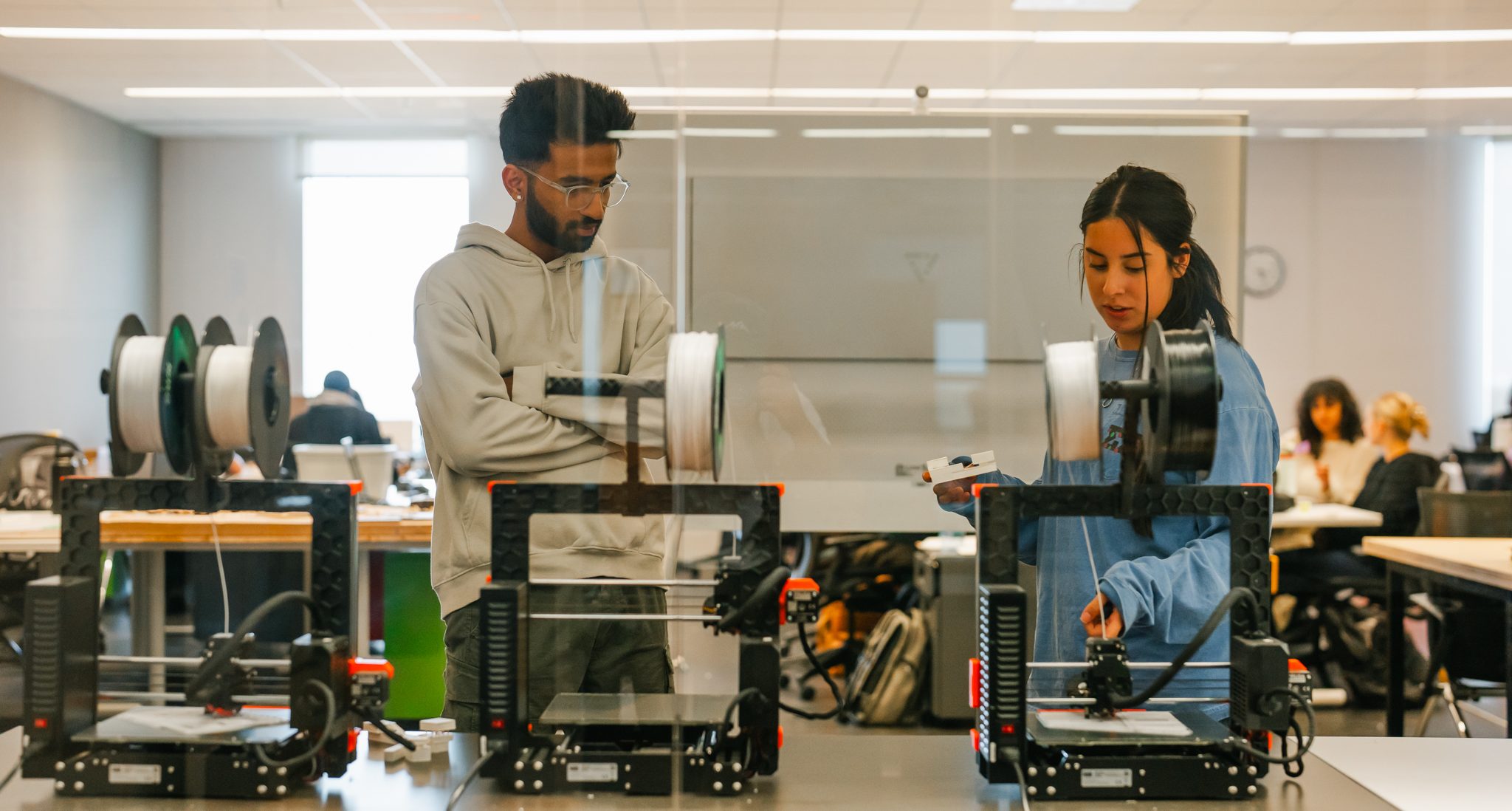 Two students at 3D printers