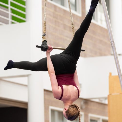 Girl hanging upside down on a trapeze