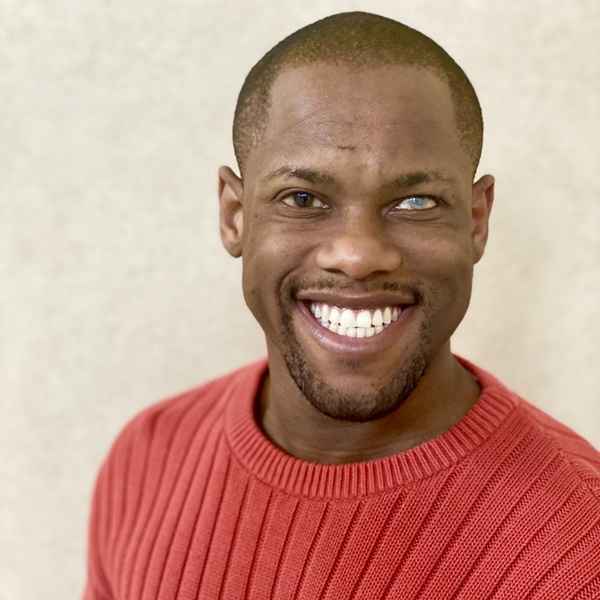 Headshot of Davian Robinson wearing an orange sweater