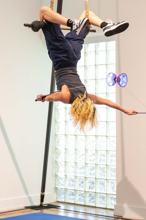 Cameron Mayhew on trapeze upside down with Diabolo