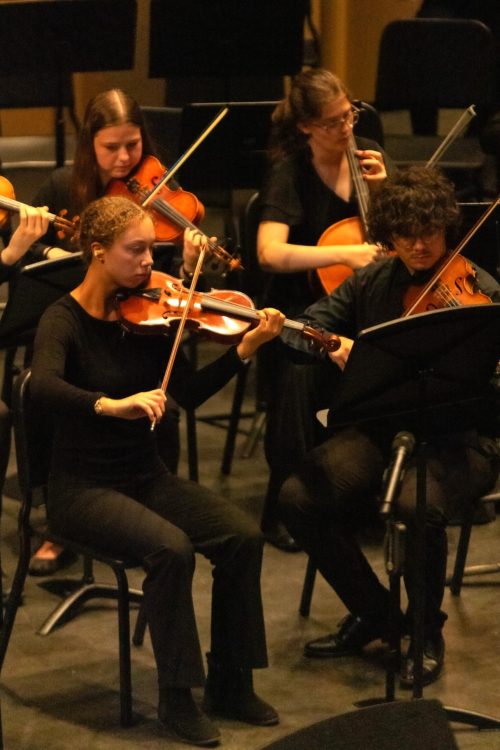 Emily Schmidt playing concertmaster in orchestra.